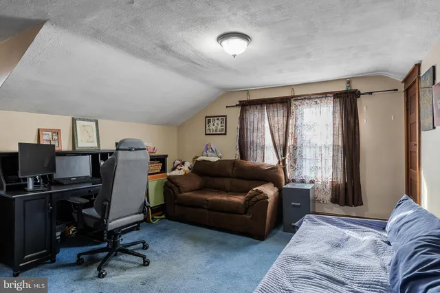 a livingroom with workspace couch and a window