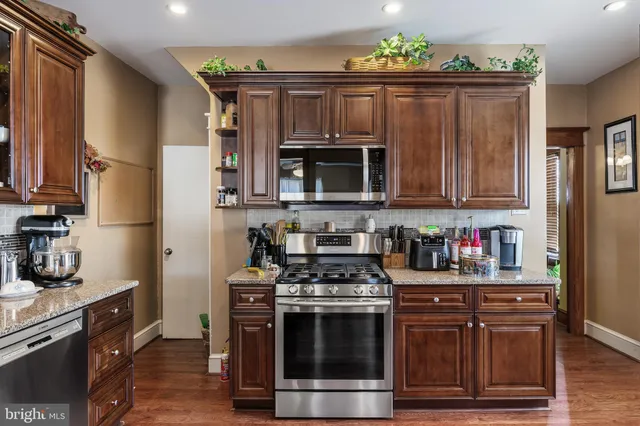 a kitchen with stainless steel appliances granite countertop a stove microwave and cabinets
