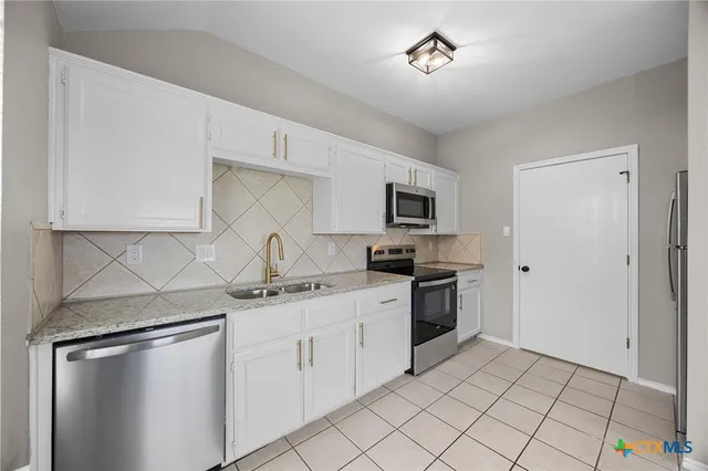 a kitchen with stainless steel appliances a sink stove and cabinets