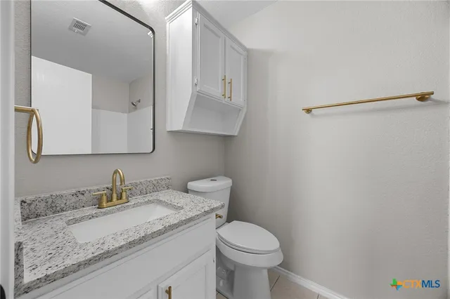 a white bath tub sitting next to a white sink and vanity