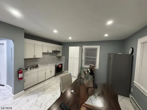 a kitchen with refrigerator a sink and wooden floor