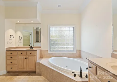 a bathroom with a tub a sink and a window