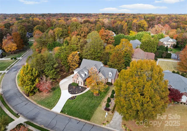 an aerial view of a house with a garden and mountains