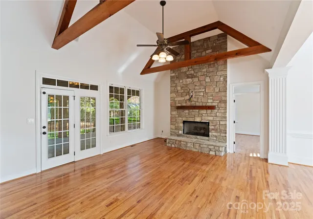 a view of a livingroom with wooden floor a ceiling fan and window