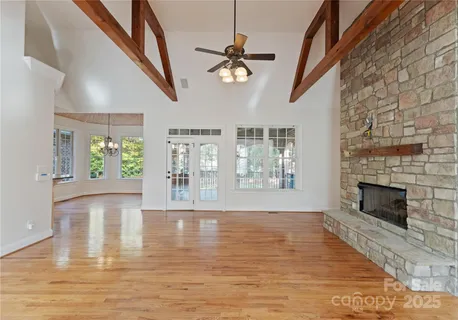 a view of an empty room with window and wooden floor