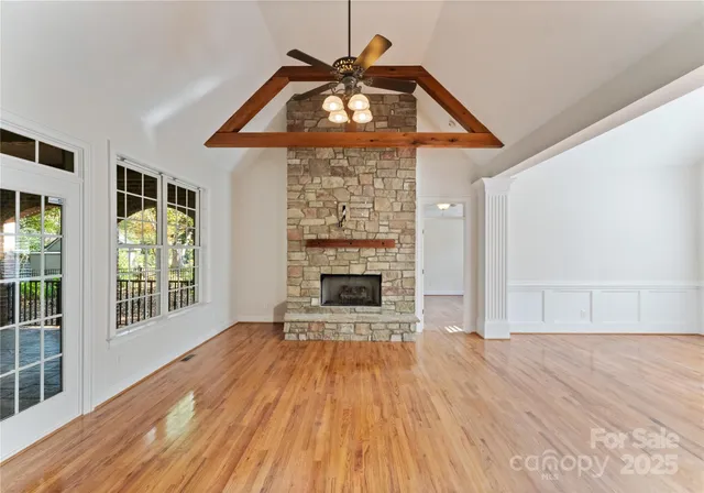 a view of empty room with wooden floor and fireplace