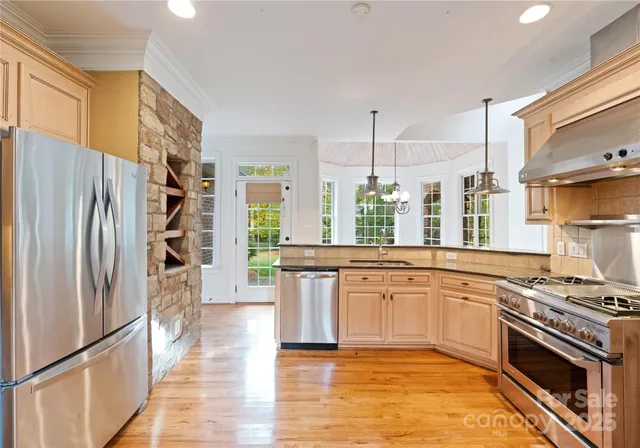 a large kitchen with stainless steel appliances granite countertop a stove and a refrigerator