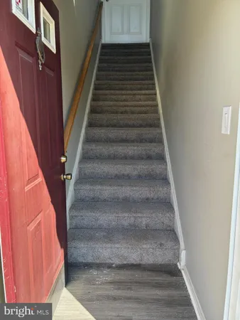 a view of staircase with white walls and white door