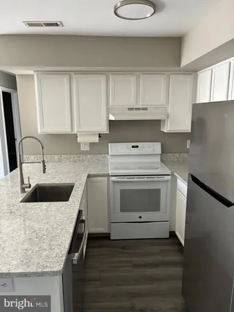 a kitchen with sink a stove and cabinets