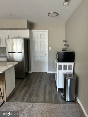 a kitchen with a refrigerator and white cabinets