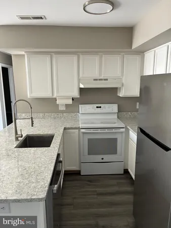 a kitchen with sink a stove and cabinets