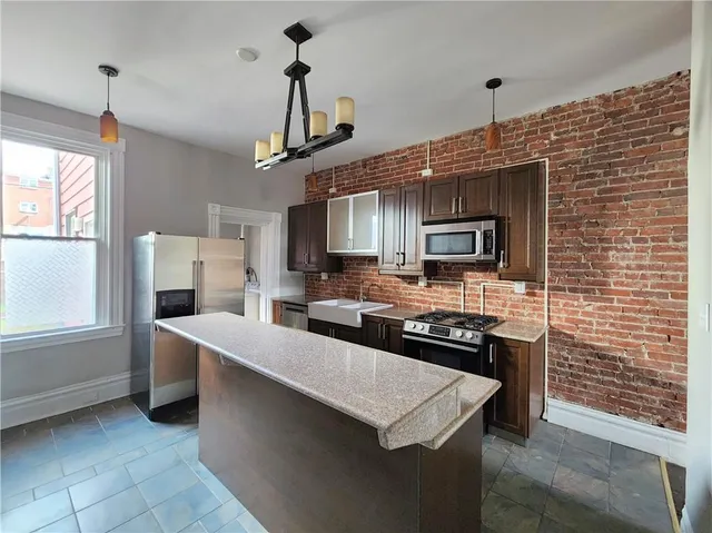 a kitchen with stainless steel appliances a stove sink microwave and refrigerator