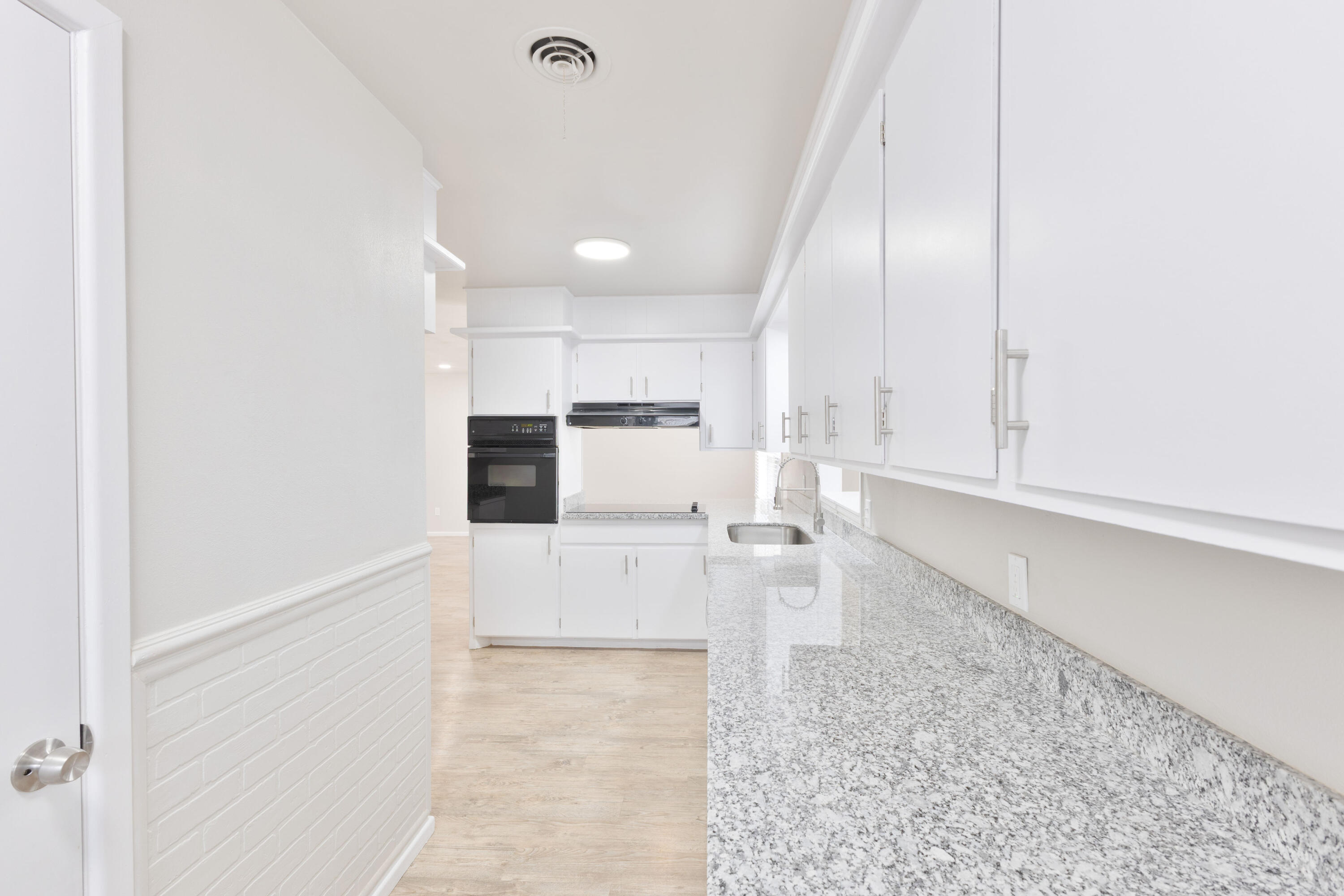 3417 52nd Street Lubbock, TX 79413 - Photo 8 of 19 a large white kitchen with white cabinets and stainless steel appliances
