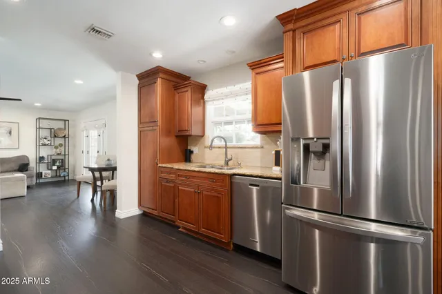 a kitchen with stainless steel appliances granite countertop a refrigerator and a sink