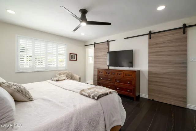 a bedroom with a bed and a flat screen tv