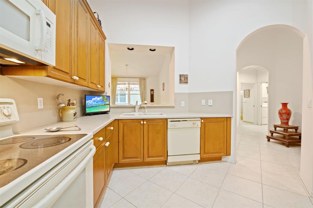 6710 Vía Roma Delray Beach, FL 33446 - Photo 12 of 35 a large kitchen with stainless steel appliances granite countertop a sink and cabinets