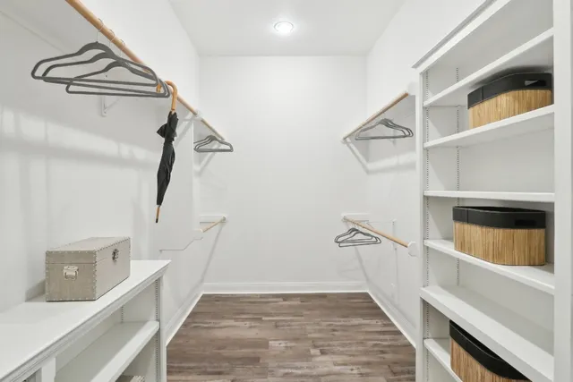 a view of a room with wooden floor and a ceiling fan