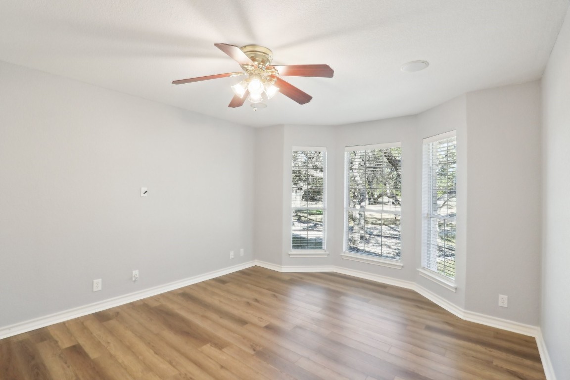 294 Logan Ranch Road Georgetown, TX 78628 - Photo 28 of 40 an empty room with wooden floor fan and windows