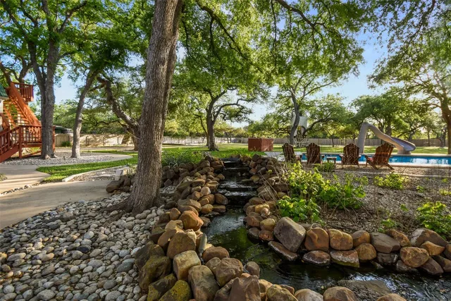 a view of a house with a big yard and palm trees