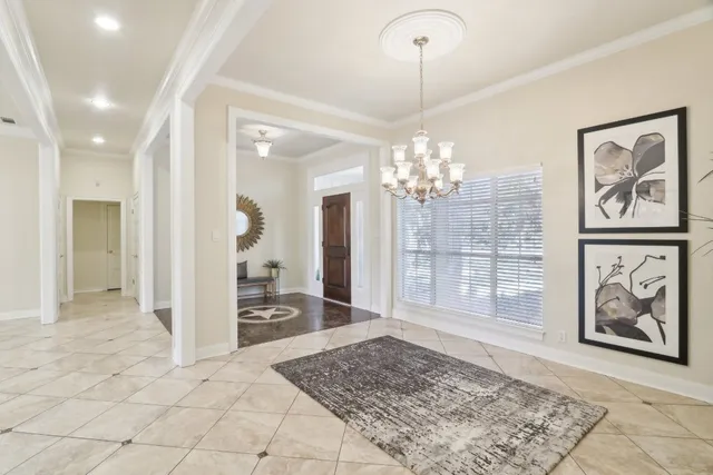 a view of a hallway with wooden floor and a chandelier