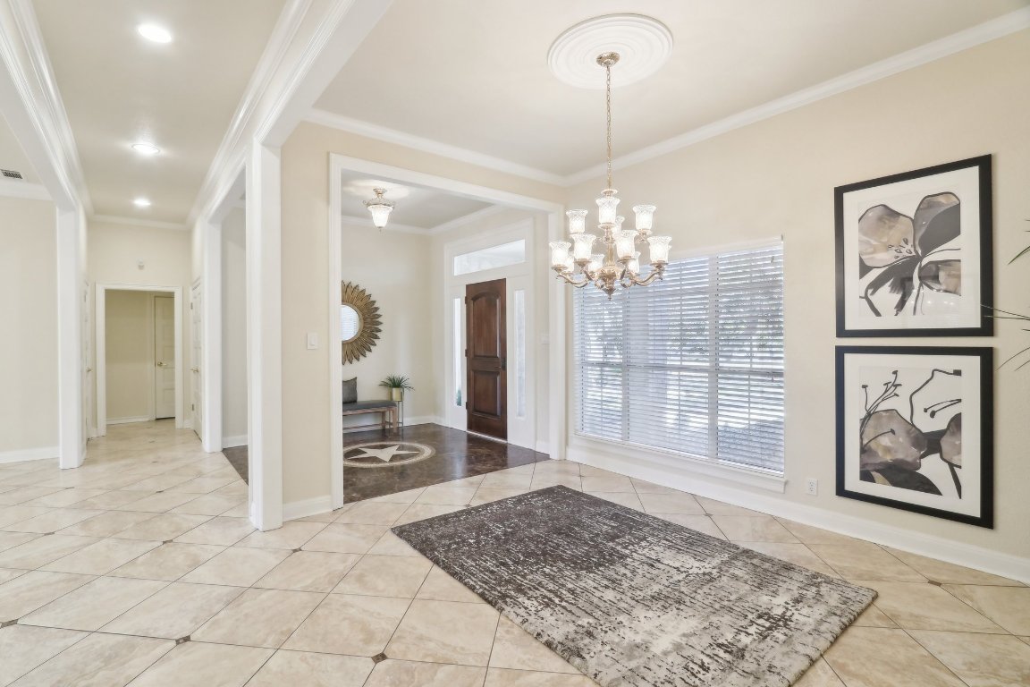 294 Logan Ranch Road Georgetown, TX 78628 - Photo 6 of 40 a view of a hallway with wooden floor and a chandelier