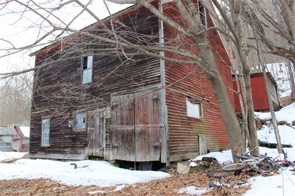 91 Foundry Village Road Colrain, MA 01340 - Photo 8 of 10 a brick building with a bench next to a road