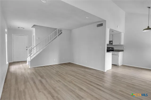 a view of a kitchen with wooden floor and stairs