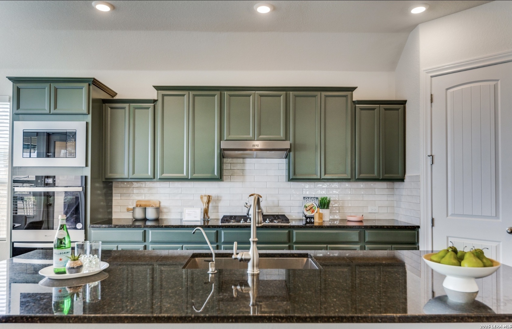 390 Rhapsody View Spring Branch, TX 78070 - Photo 11 of 28 a kitchen with a stove a sink and a microwave