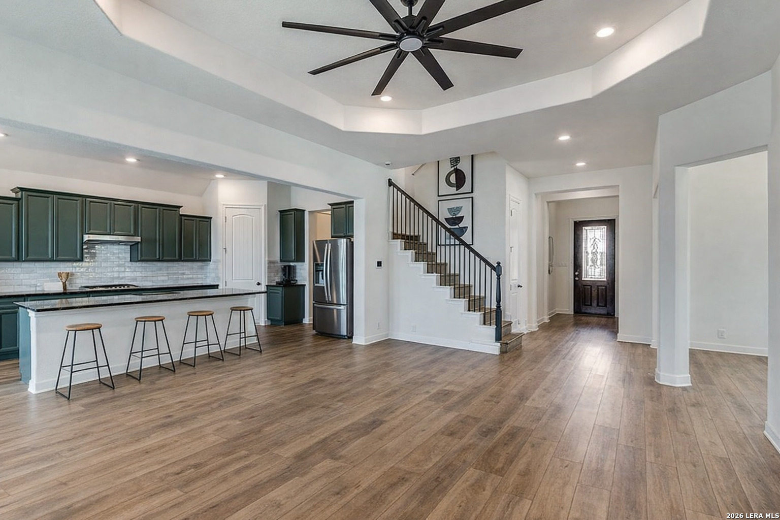 390 Rhapsody View Spring Branch, TX 78070 - Photo 9 of 28 a view of an empty room with wooden floor and a kitchen view