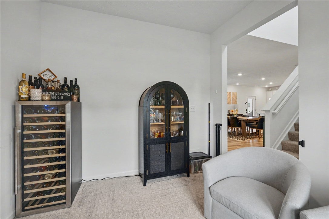 3011 Falls Road Clayton, OH 45315 - Photo 13 of 66 A well-appointed wine area featuring a dedicated cooler and glass-front cabinet for entertaining.