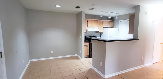 a kitchen with stainless steel appliances granite countertop a sink and a refrigerator