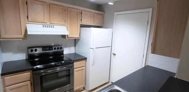 a kitchen with a refrigerator stove and cabinets
