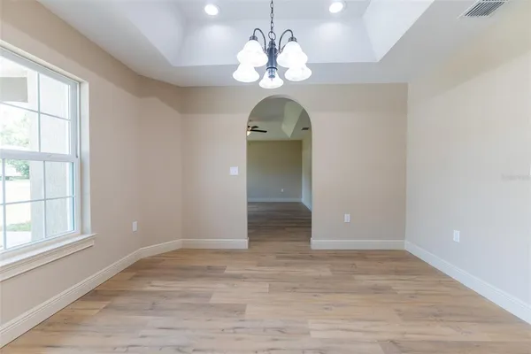 an empty room with wooden floor and window