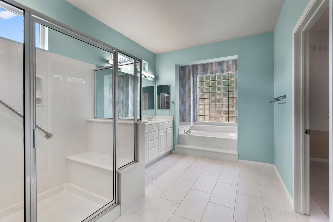 122 Nolan Drive Georgetown, TX 78633 - Photo 19 of 35 a bathroom with a glass shower door and a bathtub