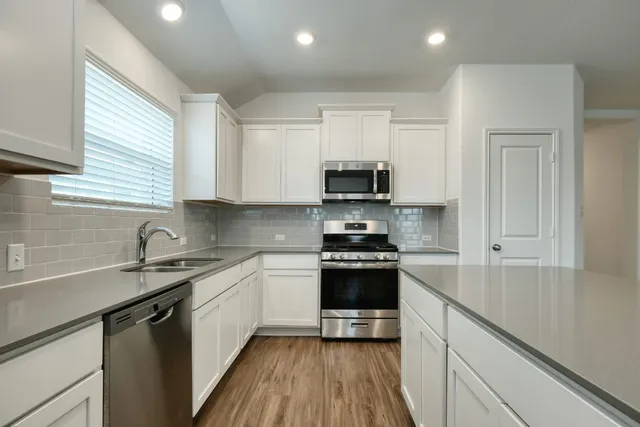 a kitchen with stainless steel appliances a sink stove and cabinets