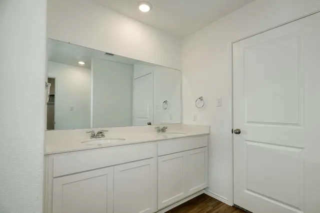 a bathroom with a double vanity sink and mirror