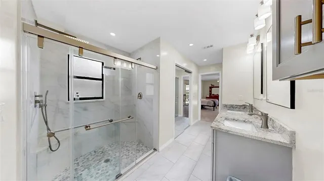 a bathroom with a granite countertop sink mirror and shower