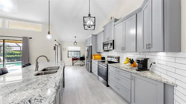 a kitchen with refrigerator a sink a stove and cabinets