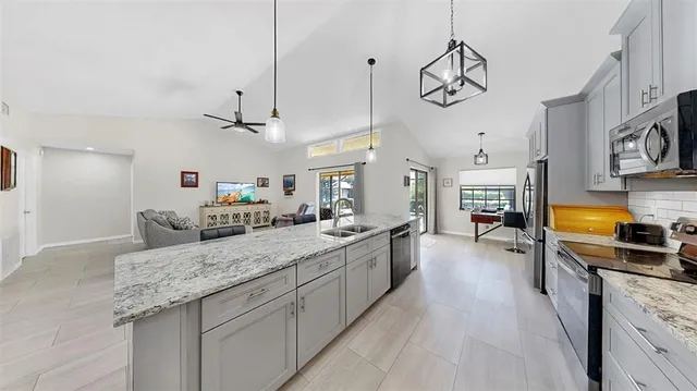 a large kitchen with kitchen island a large counter space a sink and appliances