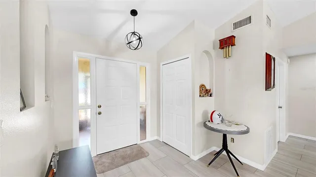 a view of a hallway with white walls and wooden floor