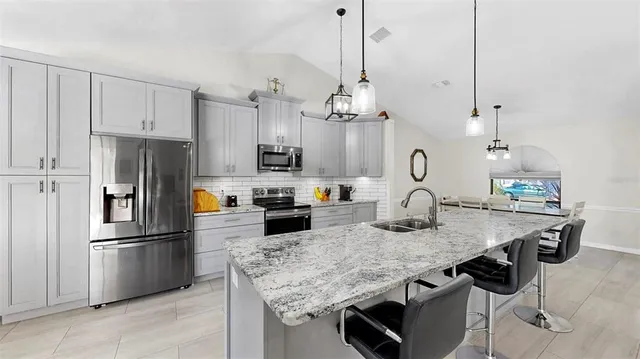 a kitchen with kitchen island a counter top space appliances and cabinets