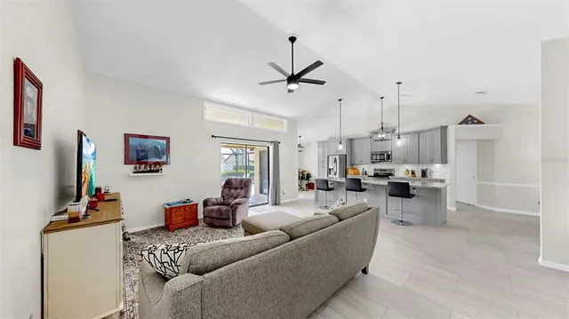 a living room with furniture a flat screen tv and a window