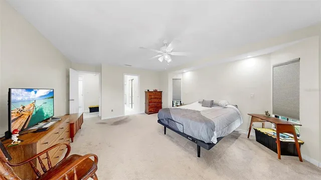 a spacious bedroom with a bed and a flat screen tv