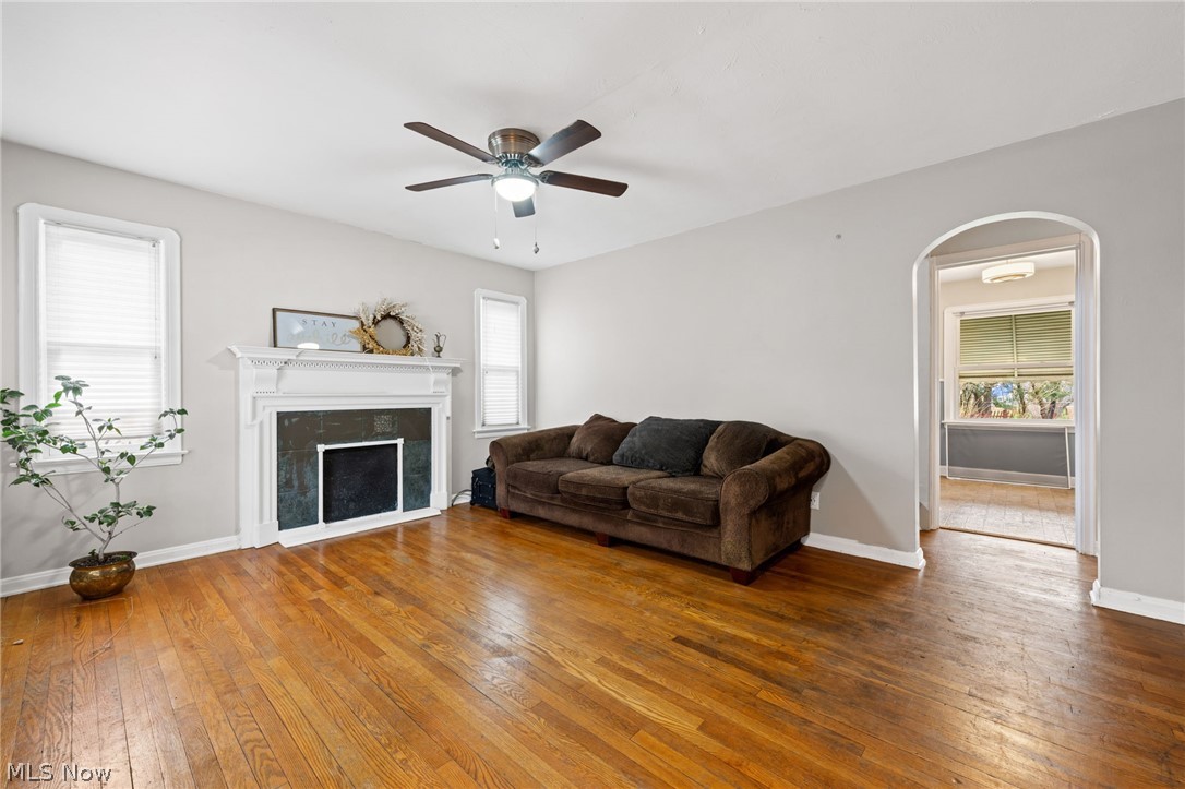 2513 Ralph Avenue Cleveland, OH 44109 - Photo 5 of 14 Living room with dark hardwood / wood-style floors, a healthy amount of sunlight, a fireplace, and ceiling fan