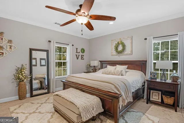 a bedroom with a large bed chandelier and a window