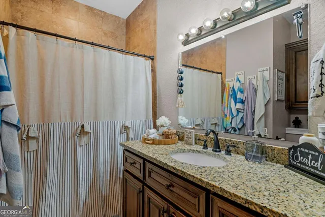 a bathroom with a granite countertop sink and a mirror