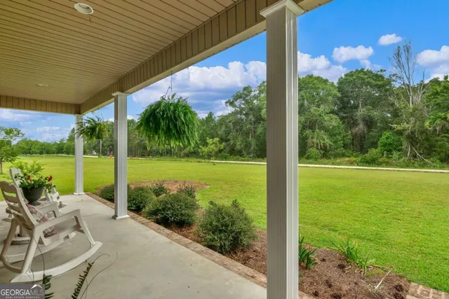 a view of a patio with dining table and chairs under an umbrella