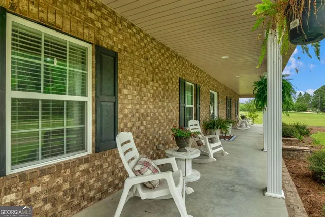 a view of a patio with table and chairs and potted plants