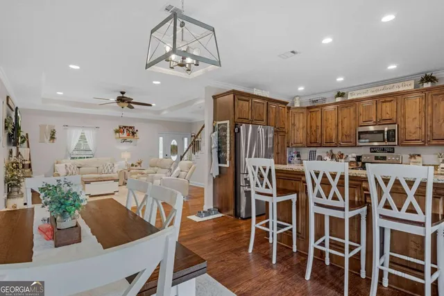 a view of a dining room with furniture a kitchen and chandelier