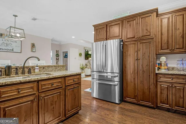 a kitchen with stainless steel appliances granite countertop a refrigerator sink and cabinets